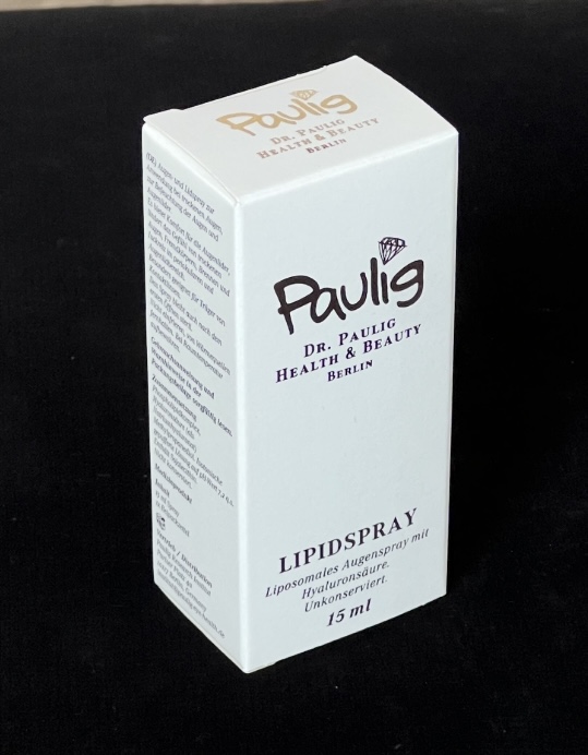 Eine weiße Schachtel mit der Aufschrift "Dr. Paulig Lipidspray" auf schwarzem Hintergrund.